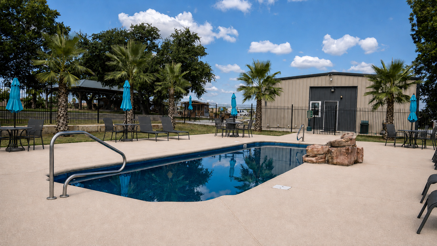 The tropical swimming pool with lounge chairs at Rivercity RV Park
